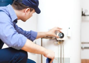 plumber doing maintenance on a water heater